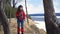 Young active happy woman hiking in mountains taking pictures using photocamera.