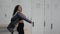 Young active lady opening locker with bracelet key and taking jacket, getting dressed after training at locker room