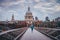 Young active man running at Millennium Footbridge over the Thames, St Paul`s Cathedral in background