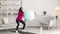 Young active middle eastern lady wearing hijab practicing squats exercise carrying fitness ball, training at home