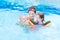 Young active mother in swimming pool with two kids