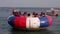 Young active people enjoy inflatable boat riding in the shallow waters of the sea