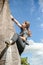 young active teen girl doing outdoor rock climbing bouldering on natural cliff