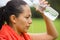 Young active woman spraying water in face