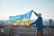 Young activist flies the Ukrainian flag in support of one sovereign state against the tyranny of another. To be heard and seen. No