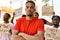 Young activist man with arms crossed gesture standing with a group of protesters holding banner protesting at the city