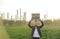 Young activist with placard standing outdoors by oil refinery, protesting.