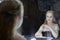 Young actress woman sits on a chair in front of a mirror in the dressing room