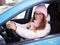 Young adorable blonde woman in pink knitted hat scarf car driver hands on wheel winter outdoors.