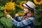 Young, adorable, energetic, female farmer standing near a sunflower with a smiley face, in the middle of a beautiful golden