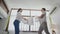 Young adult Asian couple playing pillow fight in bedroom interior scene. 30s mature husband and wife smiling and having