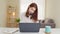 Young adult Asian woman work at home or modern office, using laptop computer and smartphone. Work from home life concept