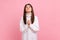 Young adult attractive brunette girl looking up with hands in prayer, sincere saying please, apology