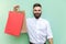 Young adult bearded man holding with many shopping bags at mall or store.