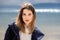 A young adult beautiful girl stands on the shore against the backdrop of an approaching cloud with rain.