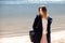 A young adult beautiful girl stands on the shore against the backdrop of an approaching cloud with rain.