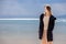 A young adult beautiful girl stands on the shore against the backdrop of an approaching cloud with rain.