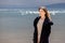 A young adult beautiful girl stands on the shore against the backdrop of an approaching cloud with rain