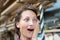 Young adult beautiful handy professional happy female carpenter with amazed surprised facial expression open mouth