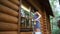 Young adult beautiful slim sporty caucasian woman in overalls stand on metal ladder and washing window wooden house