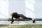 Young adult blond female doing high plank exercise outdoors