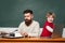 Young adult concept. Elementary school kid and teacher in classroom at school. School children. Chalkboard background