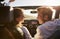 Young adult couple driving looking at each other