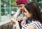 Young adult female friends listening to music through their smartphone outdoors