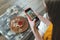 Young adult food stylist woman taking photo on smartphone