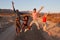 Young adult friends having fun jumping in the desert