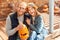 Young adult friends hugging and holding jack-o-lantern pumpkin in hands