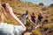 Young adult friends posing and taking photos of each other during a hike uphill on a coastal path