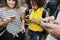 Young adult friends using smartphones in the subway