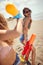 Young adult girls having fun with water-guns on a sandy beach