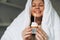 Young adult happy beautiful woman forty years plus size body positive in white blanket with festive cupcake with candle in hands