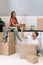 Young adult husband and wife with cardboard boxes moving in new apartment