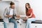 Young adult husband and wife standing in modern kitchen