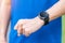 Young adult male checking time and cardio heart rate on sport smartwatch during running in the park outdoor, runner man jogging on