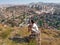 Young adult male tourist squatting on a stone looks at the panorama of Ankara Turkey from a height. Man admires the old slums