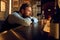 Young adult man in bar drinking whiskey from glass