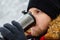 young adult man drinking coffee from refillable mug outdoors