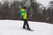 young adult man snowboarding and taking selfie on action camera