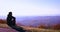 Young adult man, traveller enjoys the view on misty mountain ridges in morning light