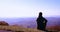 Young adult man, traveller enjoys the view on misty mountain ridges in morning light