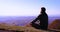 Young adult man, traveller enjoys the view on misty mountain ridges in morning light