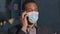 Young adult mixed race professional, wearing medical face mask businessman making business call talking on the phone