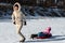 Young adult mother wear warm jacket enjoy have fun sledging two cute little sibling kids boy girl at frozen white snow