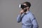 Young adult smart casual businessman wearing head mounted vr headset looking away at copyspace and thinking