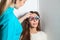 young adult woman checks vision in an ophthalmologist with corrective lenses