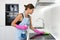 Young adult woman cleaning electric stove in kitchen